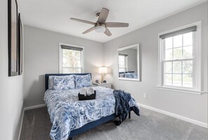 Third bedroom with queen sized bed and ceiling fan.