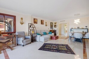 Bright space that has a table for 6 people, a living room with a sofa bed and TV. (2)