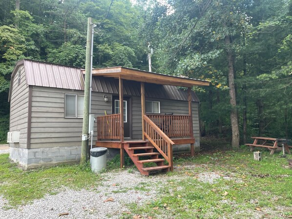 Cabin Outside with picnic table and grill.