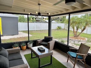 Screened patio seating area with ceiling fan