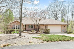 Embrace the beauty of home with this picturesque residence, nestled among towering trees and featuring a spacious garage.