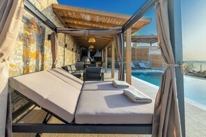 The pool area is well-appointed with 5 sunbeds, an outdoor swing, a charming gazebo, and a poolside shower, as well as a lawn-covered area next to it.
