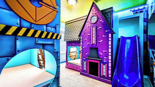 Whimsical kids' dream room with slides, bunk beds, and colorful playhouse!
