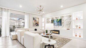 Chic modern living room with marble accents, cozy fireplace, and luxe seating