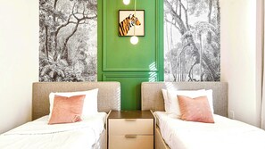 Chic twin room with jungle mural accents, modern lighting, and cozy vibes!
