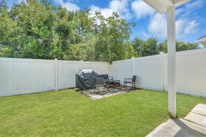 Peaceful backyard with patio seating and gas grill