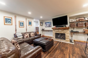 Living area offering a wood-burning fireplace, cozy furnishings and a smart TV.