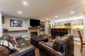 Living area offering a wood-burning fireplace, cozy furnishings and a smart TV.