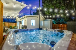 Jacuzzi with night lights overlooking patio and putting green
