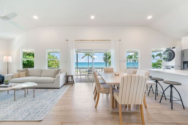 Step into our newly renovated living room, boasting sleek design and direct views over an expansive patio, the inviting pool, and the tranquil ocean beyond