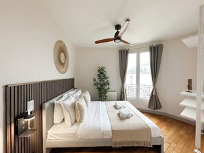 Bedroom full of light with ceiling fan and storage