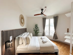 Bedroom full of light with ceiling fan and storage