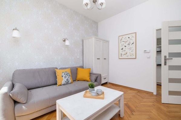 A cozy living area featuring a soft gray sofa adorned with decorative cushions.