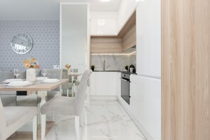A fully equipped kitchen with white cabinetry, wooden accents, and modern appliances for a sleek and functional design.