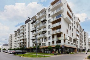 An exterior view of the modern apartment building, showcasing its contemporary architecture and landscaped surroundings.