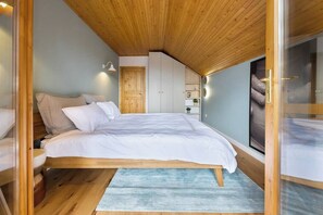 Bedroom with queen size bed, premium linens, clothing storage, dedicated workspace and access to the first floor terrace.