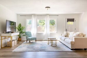 Embrace the bohemian vibes in our cozy living room. With a charming wood floor, this space is adorned with a comfy chair, a stylish couch, and a chic coffee table in front of the TV!