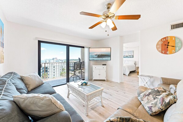 Spacious living room bathed in natural light, featuring plush seating and breathtaking ocean views.