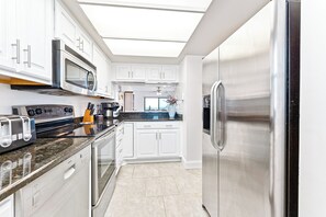 Sleek and modern kitchen with stainless steel appliances, granite countertops, and plenty of storage.