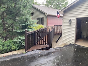 Charming house with beige and red siding, a wooden deck, garage, and an American flag.