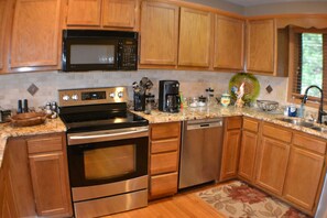 Modern kitchen with stainless steel appliances, ample storage, and a coffee maker.