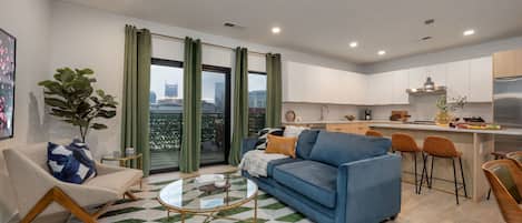 Designer furnished living room featuring a Smart TV and patio access with city views.