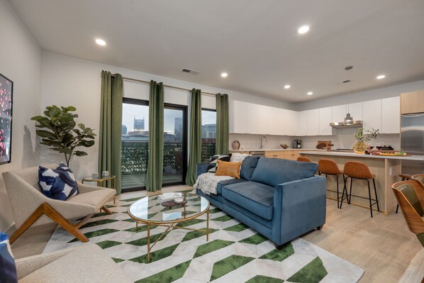 Designer furnished living room featuring a Smart TV and patio access with city views.