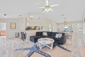 Large open living room with sleeper sectional, accent chair, and smart TV.