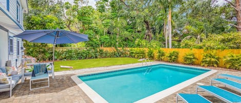 Relax in the tropical palm tree lined backyard with an outdoor sectional, pool loungers, outdoor dinning for 10 and a year round heated salt water pool.