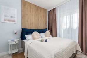 A serene bedroom with a comfortable double bed, wooden accent wall, and soft bedding for a restful ambiance.

