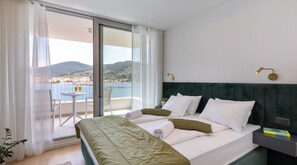 A comfortable bedroom with a king-size bed and a private balcony on the top floor of a luxury Croatian villa for rent