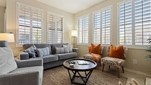 Unwind in the light-filled living room with curated decor, soft textiles, and a comfortable layout made for conversation