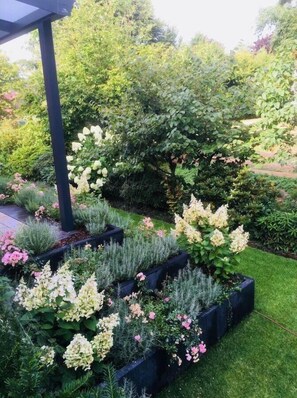 Überdachte Terrasse mit blühendem Garten