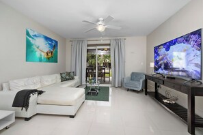 Step into the inviting living area featuring a plush, L-shaped sofa that offers plenty of space to stretch out and relax. Whether you're enjoying a quiet morning coffee or gathering with loved ones, this cozy setup is perfect for any moment.