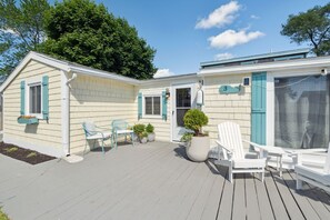Front deck with outdoor couch, umbrella, and Adirondack chairs