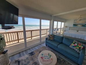 Living space with floor to ceiling windows that offer a beach view along with the master bedroom that opens and closes off with a privacy wall