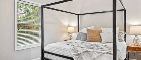 Modern primary bedroom with king bed, walk-in closet, and ensuite bath.