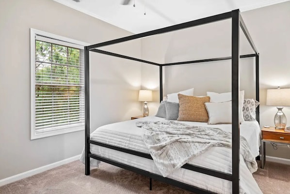 Modern primary bedroom with king bed, walk-in closet, and ensuite bath.