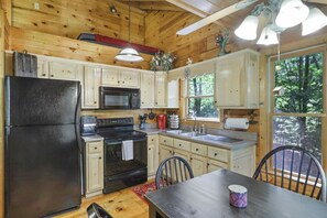 Loft above kitchen cabinets has smaller bed. 