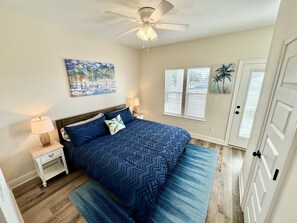 Tropical master suite with a king bed and a balcony with bay views.