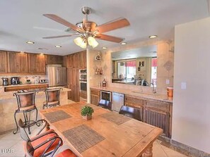 The beautiful kitchen has ample countertop space and a large dining room table.