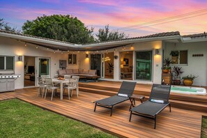 Florida Dreamscape: Immerse Yourself in Outdoor Splendor with Dining for Six, a Grilling Haven, and Lounge Area, All Beneath the Enchanting Pink Skies. Your Sunset Paradise Awaits.