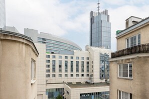 A balcony offering city views, complete with a small table and chairs for outdoor relaxation.

