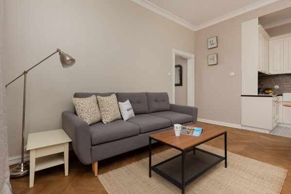 A cozy living room with a gray sofa, a coffee table, and neutral tones creating a relaxing ambiance.

