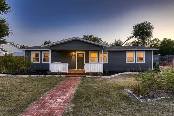 Inviting front entry with lush greenery and a well-maintained lawn