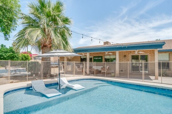 Private pool with in-pool lounge chairs and child safety gate. 