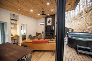 Indoor-outdoor flow with direct access to the hot tub and wooded views.