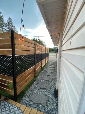 Private entry from dedicated parking spot with outdoor lights and grape vines 