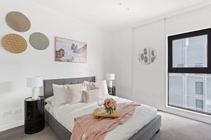 The master bedroom with a double sized bed & plush pillows.