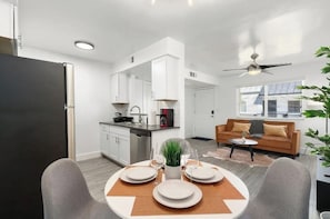 Chic four-person dining table with an overview of the living room.